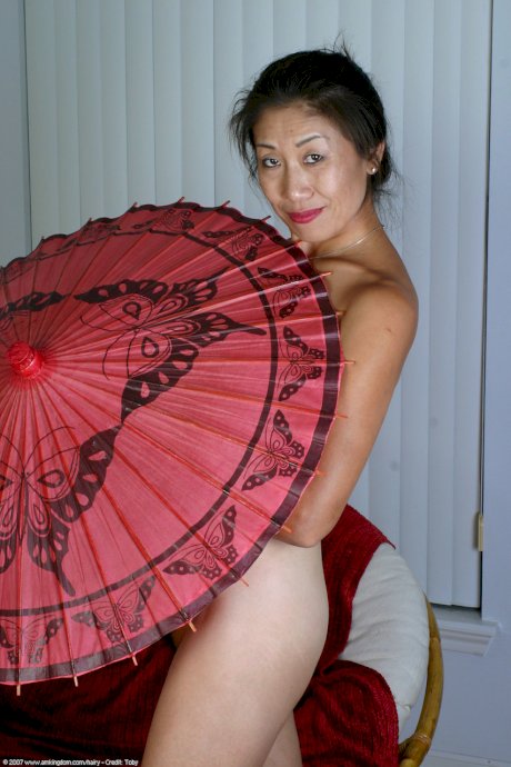 Hot Asian lady Hana getting naked and playing with her hairy mature pussy