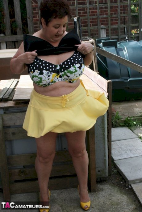 Fat older woman Kinky Carol flashes her bra and upskirt underwear on a patio