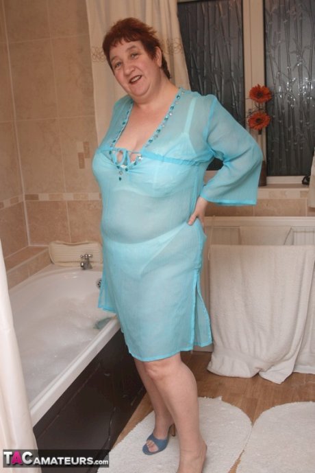 Redhead nan Kinky Carol parks her fat figure in a tub while fully clothed