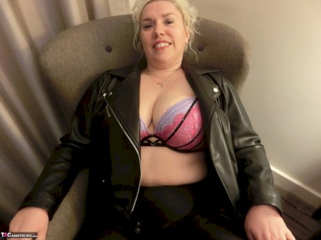Mature blonde Barby strips to her heels before masturbating on a bed