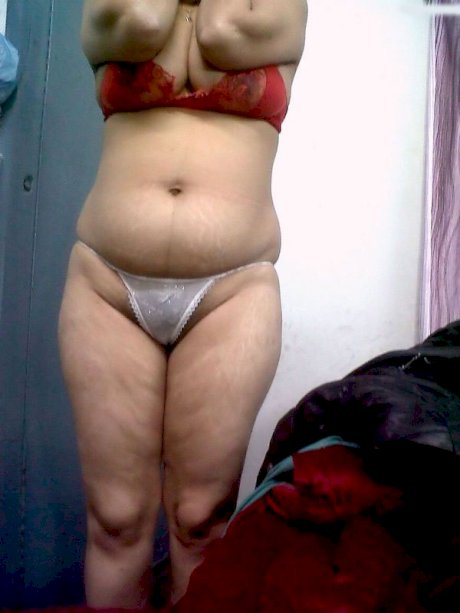 Fat Indian woman hides her face while adorned in a bra and thong