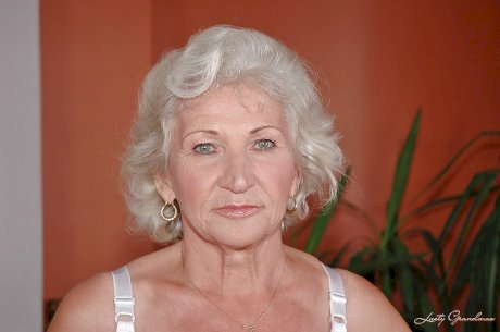 Lustful granny in white stockings masturbating her twat with a big dildo
