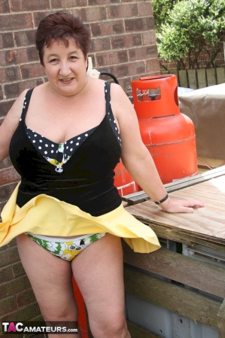 Fat older woman Kinky Carol flashes her bra and upskirt underwear on a patio