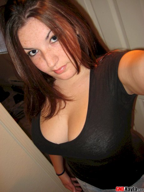 Amateur girl licks her lips while lifting up her shirt during self shot action