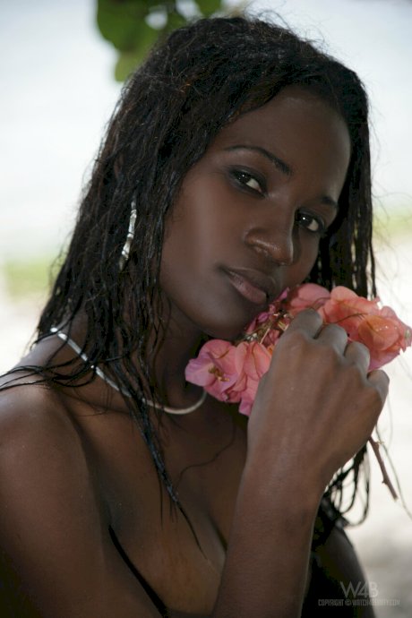 Exotic ebony Jessica exposes her big tits while posing topless on the beach