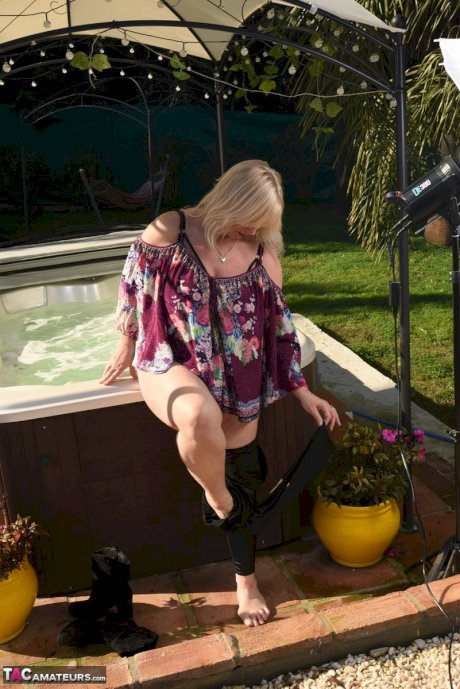 Fat older blonde Melody peels off black leggings afore an outdoor hot tub