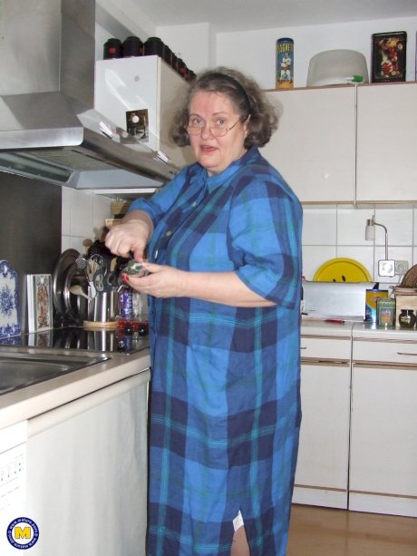 Fat mature housewife Birgid masturbates with a cucumber in the kitchen