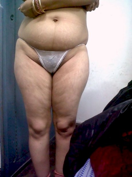 Fat Indian woman hides her face while adorned in a bra and thong