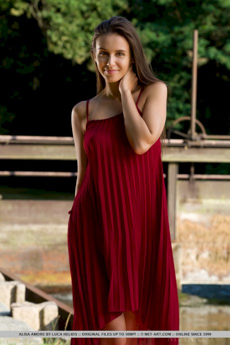 Beautiful teen Alisa Amore disrobes for nude solo poses near a dam