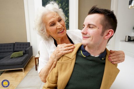 Old woman kisses a young man while seducing him for a badly needed fuck