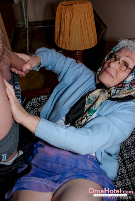 Cute granny with glasses Agnes strips and massages a nice fat dick