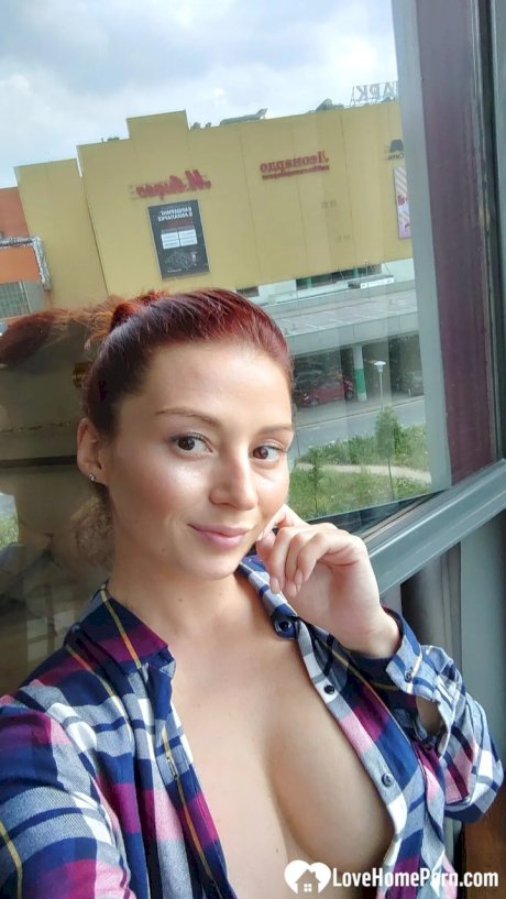 Gorgeous redhead shows off her big tits & her tattoos while taking nudes