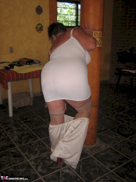 Fat granny Girdle Goddess holds her saggy tits in her hands by a pillar