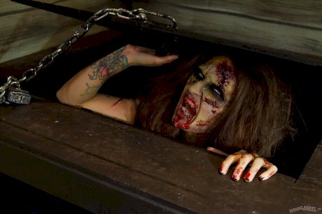 Saucy brunette cosplayer Kleio unveils her zombie tits and pussy