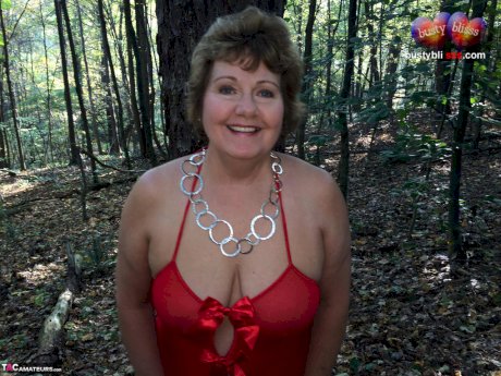 Older lady Busty Bliss gets completely naked while in a forest