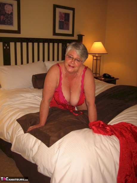 Fat granny Girdle Goddess whips out her big boobs on a bed in pantyhose
