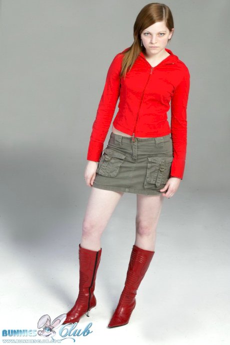Pale redhead Lilly slowly strips to a black G-string and red leather boots