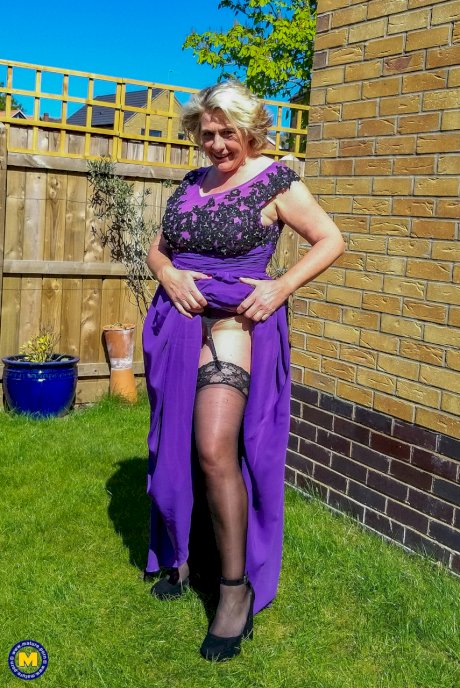 Old blonde woman flashes her garters in a yard before sex in the kitchen