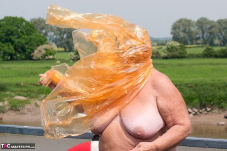 Obese oma Grandma Libby doffs a see-through raincoat to get naked on a bridge