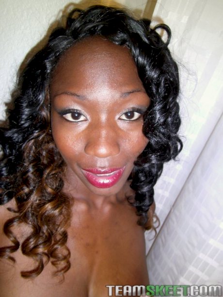 Sassy ebony sweetie stripping down and exposing her ample bosoms
