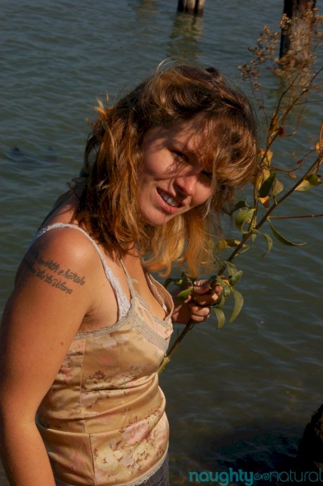 Saucy young slut Lilah strips by the water and unveils her hairy body