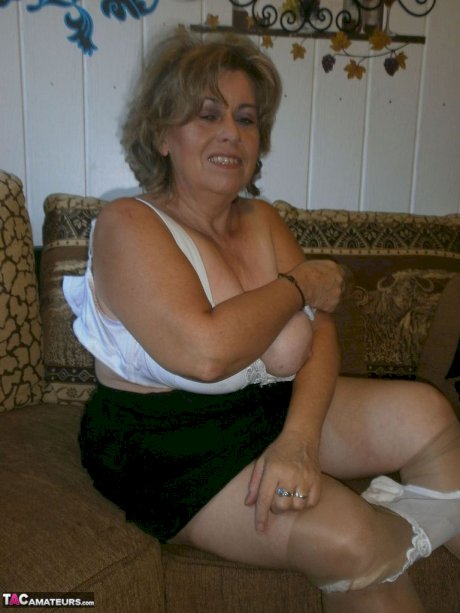 Old woman with large boobs pulls down pantyhose to finger her natural pussy