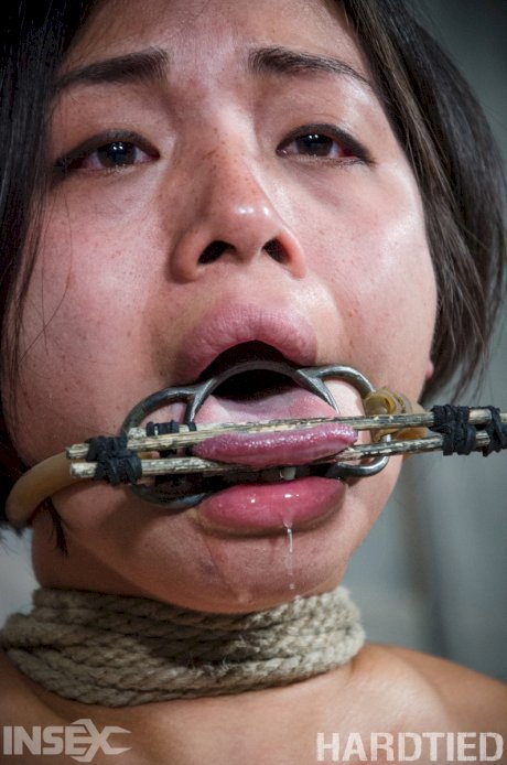 Asian girl Milcah Halili drools spit while restrained in a dungeon