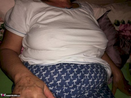 Horny older woman licks her nipple before dildoing her hairy pussy