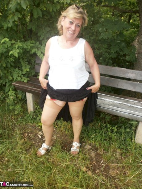 Mature amateur whore Caro masturbating on the bench in the woods