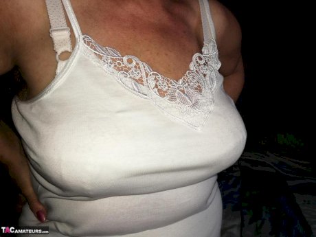 Naughty granny exposes her boobs while changing attire in nylons and heels