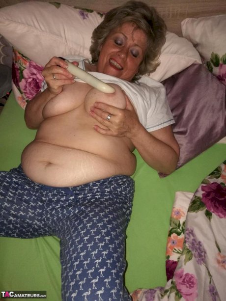 Horny older woman licks her nipple before dildoing her hairy pussy