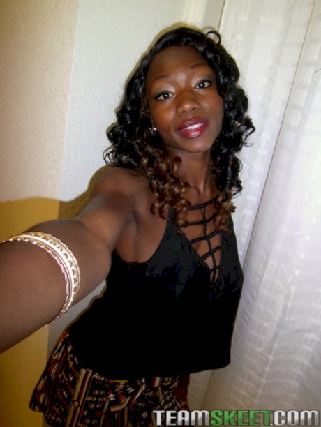 Sassy ebony sweetie stripping down and exposing her ample bosoms