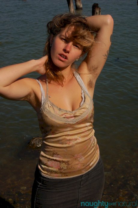 Saucy young slut Lilah strips by the water and unveils her hairy body
