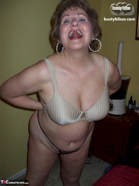 Mature woman Busty Bliss uncups her natural tits while wearing a black thong