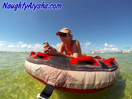Big titted amateur lounges on an air mattress while naked in a ball cap