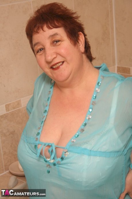 Redhead nan Kinky Carol parks her fat figure in a tub while fully clothed