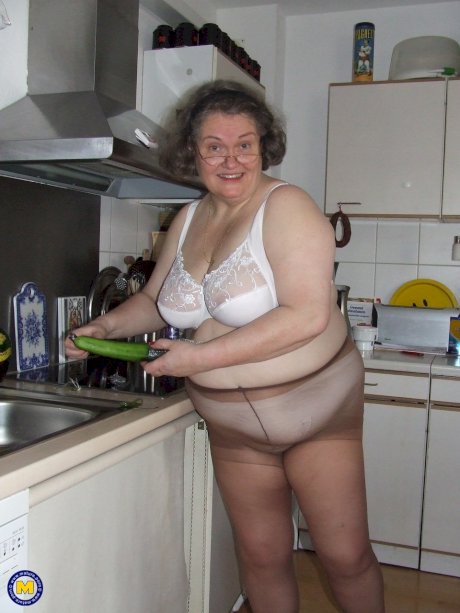 Fat mature housewife Birgid masturbates with a cucumber in the kitchen