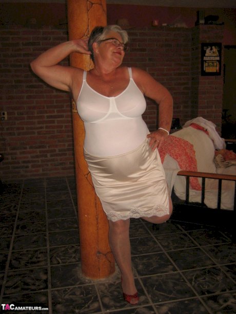 Fat granny Girdle Goddess holds her saggy tits in her hands by a pillar