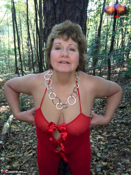 Older lady Busty Bliss gets completely naked while in a forest