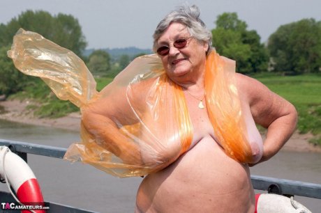 Obese oma Grandma Libby doffs a see-through raincoat to get naked on a bridge