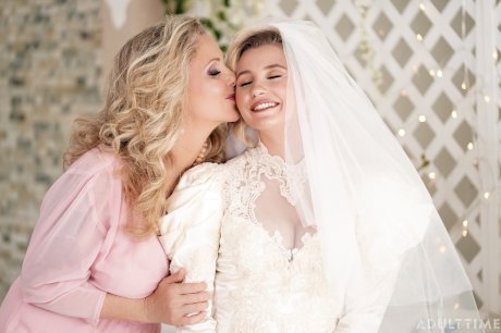 Carolina Sweets is affixed with a garter before a lesbian wedding to Julia Ann