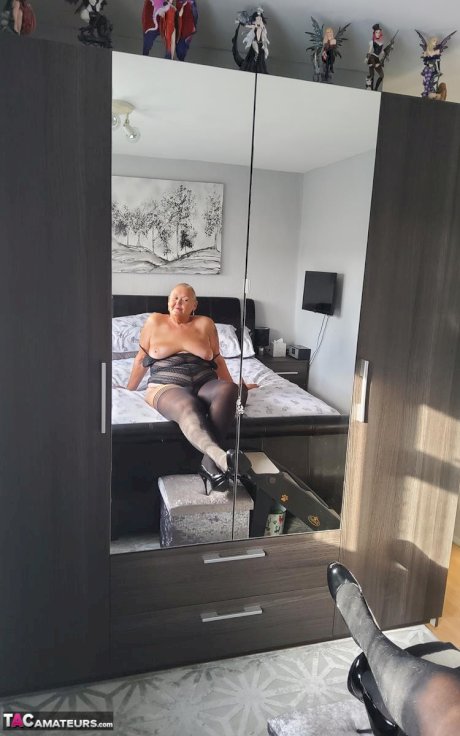 Overweight granny Valgasmic Exposed uncovers her boobs on her bed in stockings