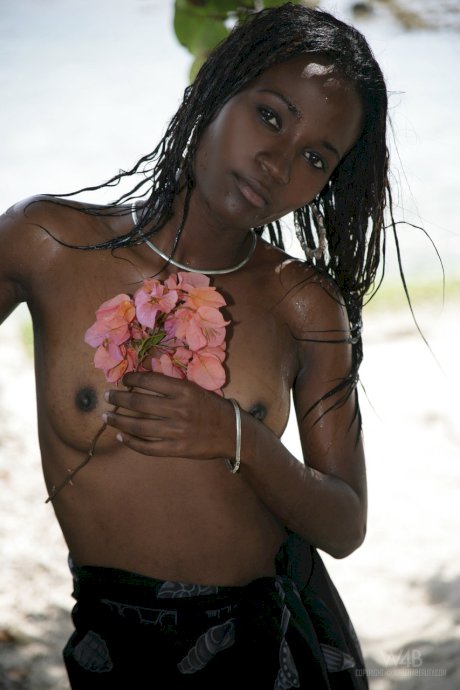 Exotic ebony Jessica exposes her big tits while posing topless on the beach