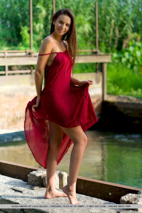 Beautiful teen Alisa Amore disrobes for nude solo poses near a dam