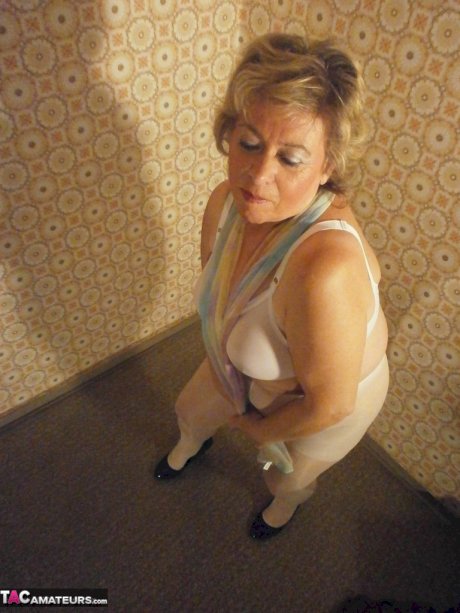 Big ass mature lady Caro posing in white pantyhose and black high heels