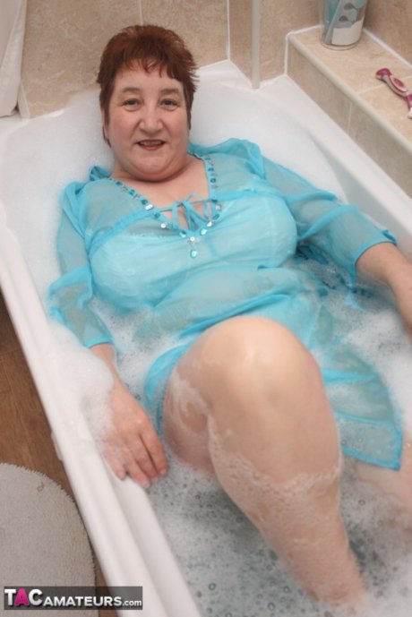 Redhead nan Kinky Carol parks her fat figure in a tub while fully clothed