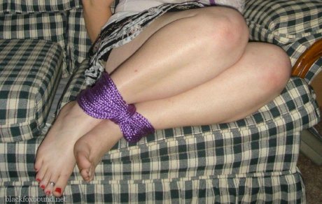 Overweight girl has her hands tied behind her back while her ankles are bound