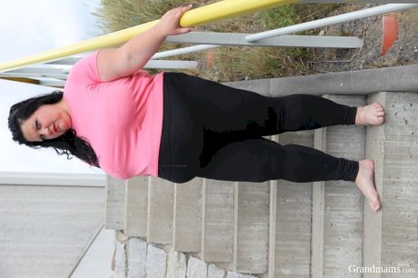 Buxom granny shows her cleavage and sucks a knob on an outdoor stairway