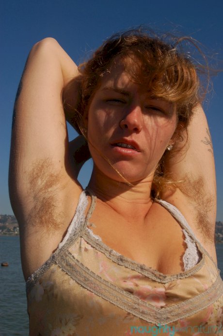 Saucy young slut Lilah strips by the water and unveils her hairy body