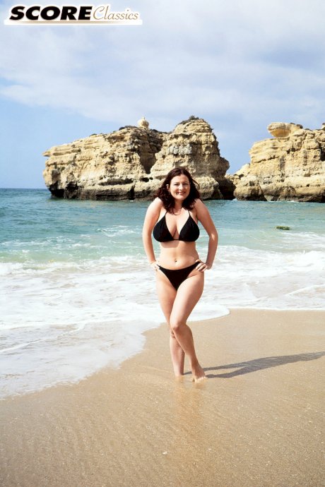 Brunette MILF Lorna Morgan releases her nice melons from bikini on a beach